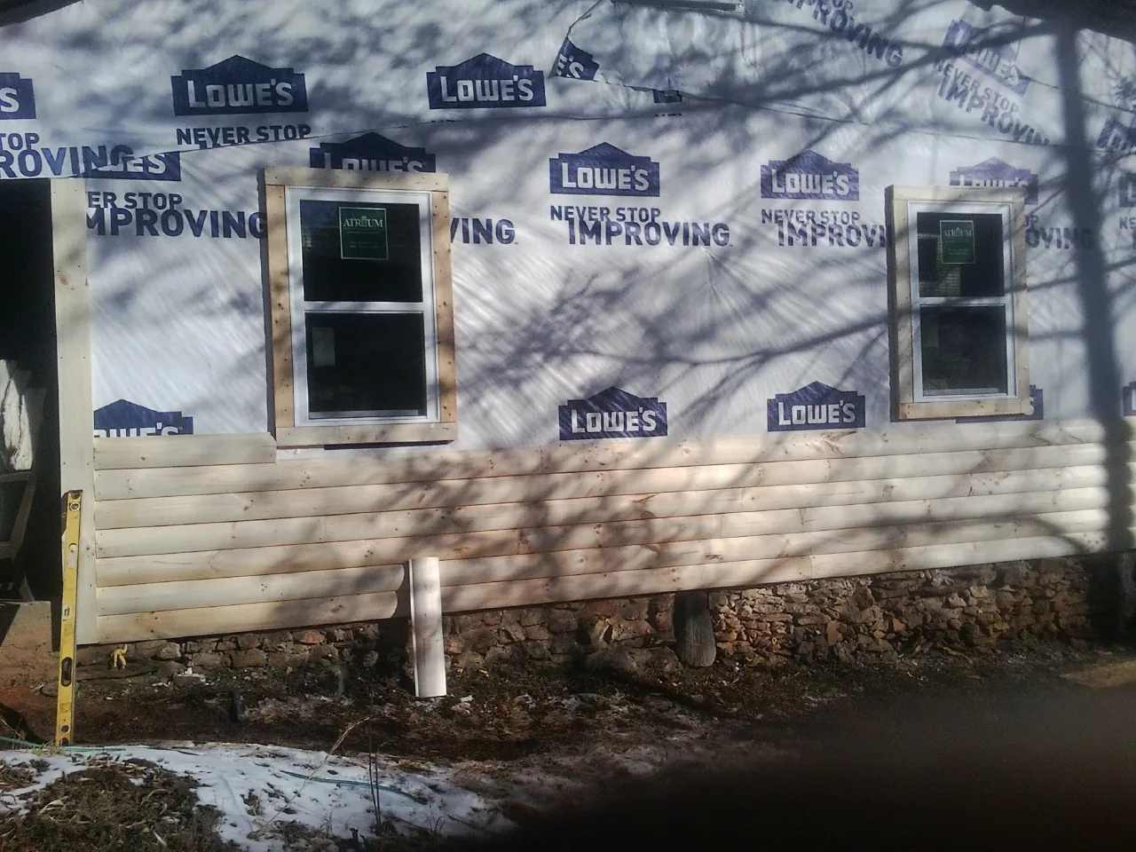 House wrap and new log siding going up on an exterior wall in Grand Island