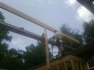 Carpenter setting a ridge beam over a new addition frame — Ice Dam Removal by Roofing Brothers in Grand Island