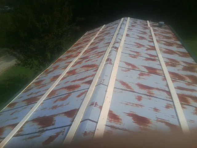 Rusted metal roof panels with new wood purlins before replacement — Storm Damage Roof Repair in Grand Island by Roofing Brothers