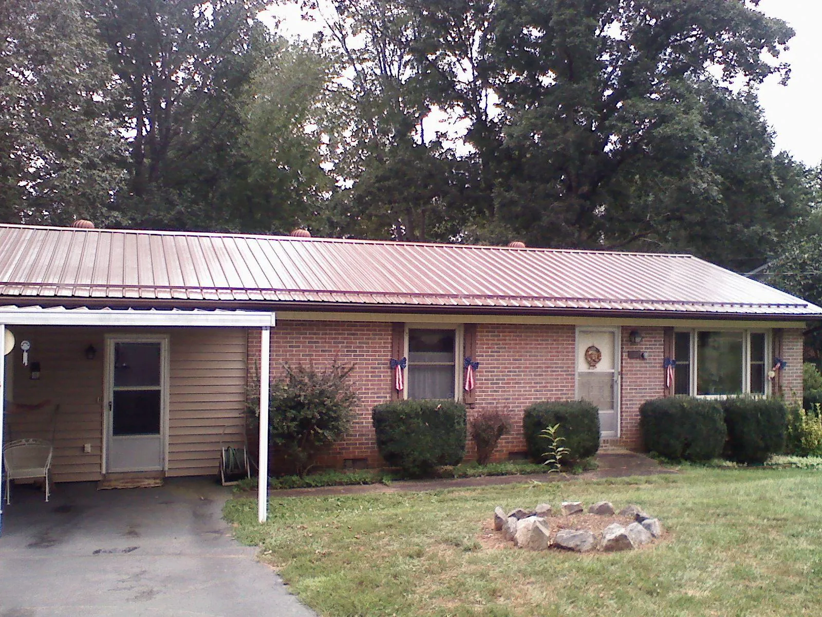 Bronze metal roof and carport on a brick ranch home — Roof Repair work by our crew in Grand Island