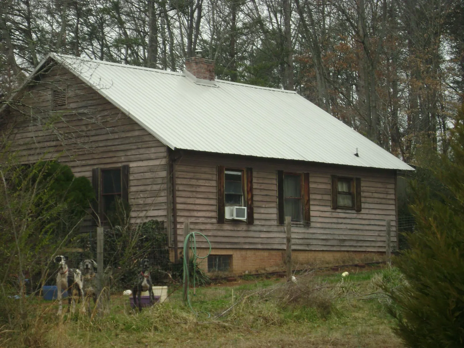 White metal roof on an old wood sided farmhouse, from a Metal Roof Installation job in Grand Island